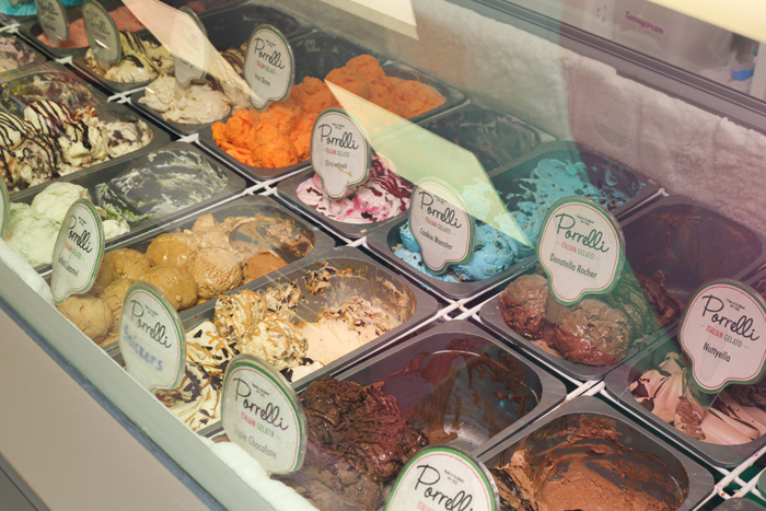 Display case showcasing multiple tubs of colourful artisan ice cream and gelato 
flavours at Candy Cream shop in Bathgate