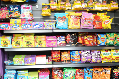 Interior view of Candy Cream Bathgate showing shelves stocked with packaged 
international sweets, crisps, candy, and American snacks like Nerds and Cheetos